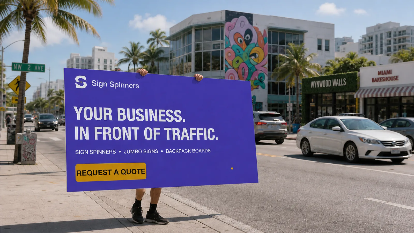 Street advertising concept showing a large purple Sign Spinners board near a road