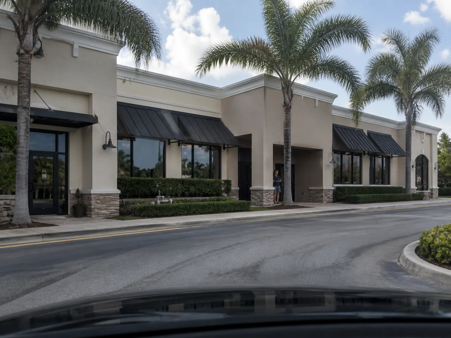 Driver approaching a South Florida shopping plaza with an easy-to-miss recessed entrance