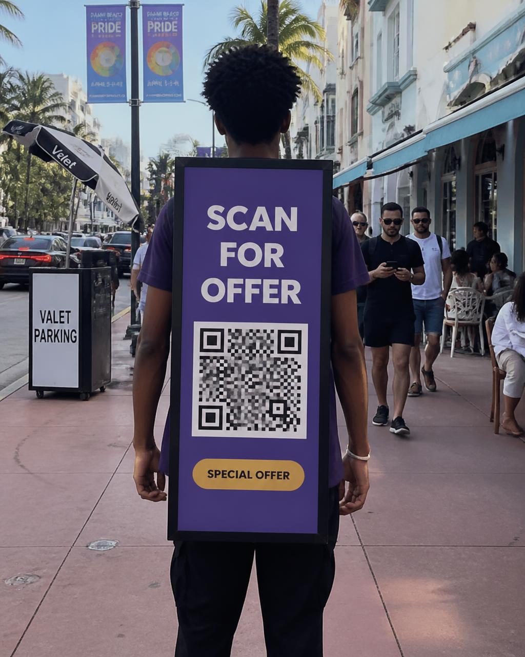 Walker on a Miami sidewalk wearing a purple backpack board with a QR code